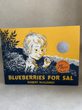 Kids Book cover of 'Blueberries for Sal' by Robert McCloskey with a child illustration on a yellow and blue background.