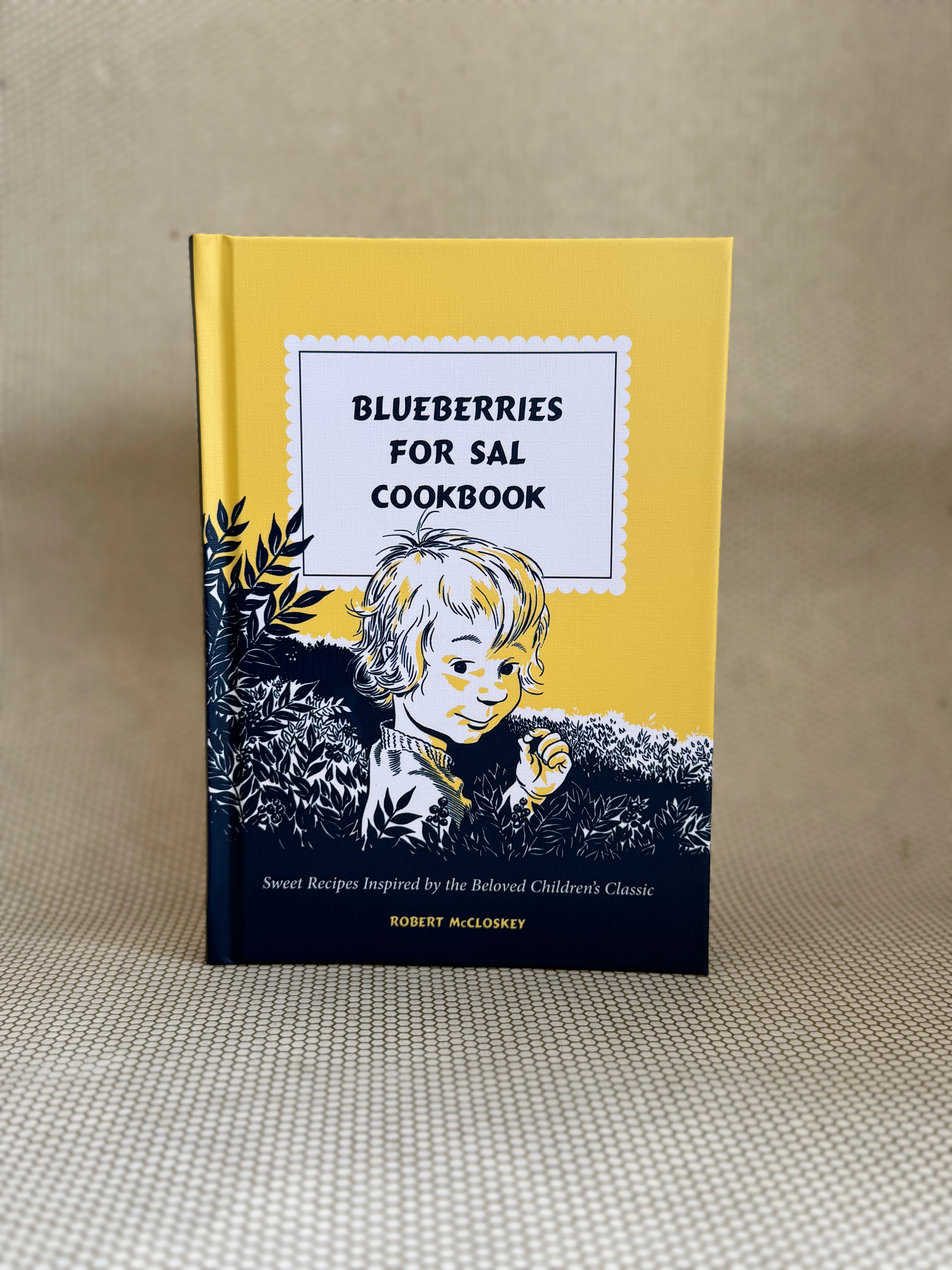 Cookbook titled 'Blueberries for Sal' with a child illustration on a beige background.