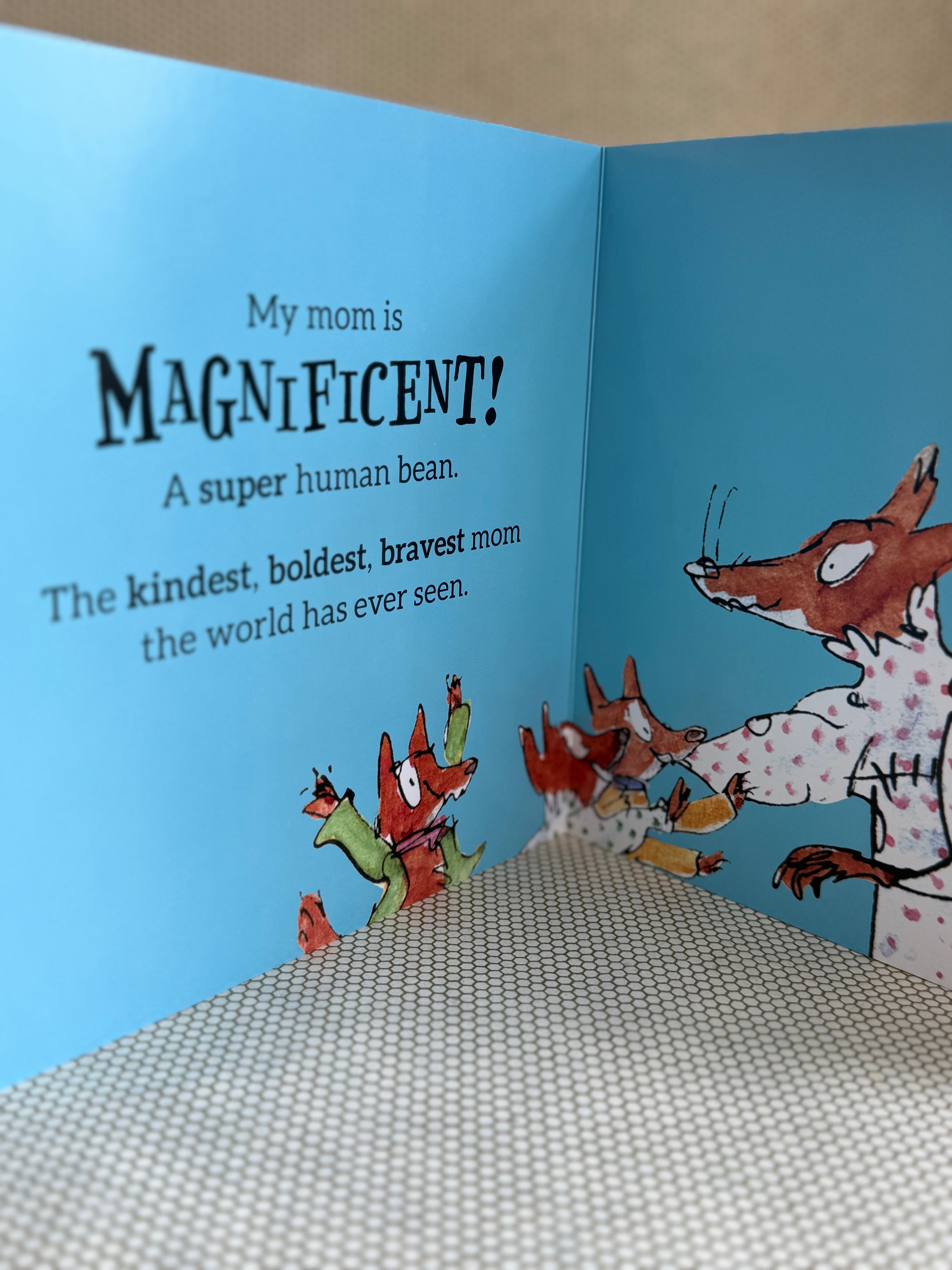 Children's book open to a page with text and illustrations of a fox family.