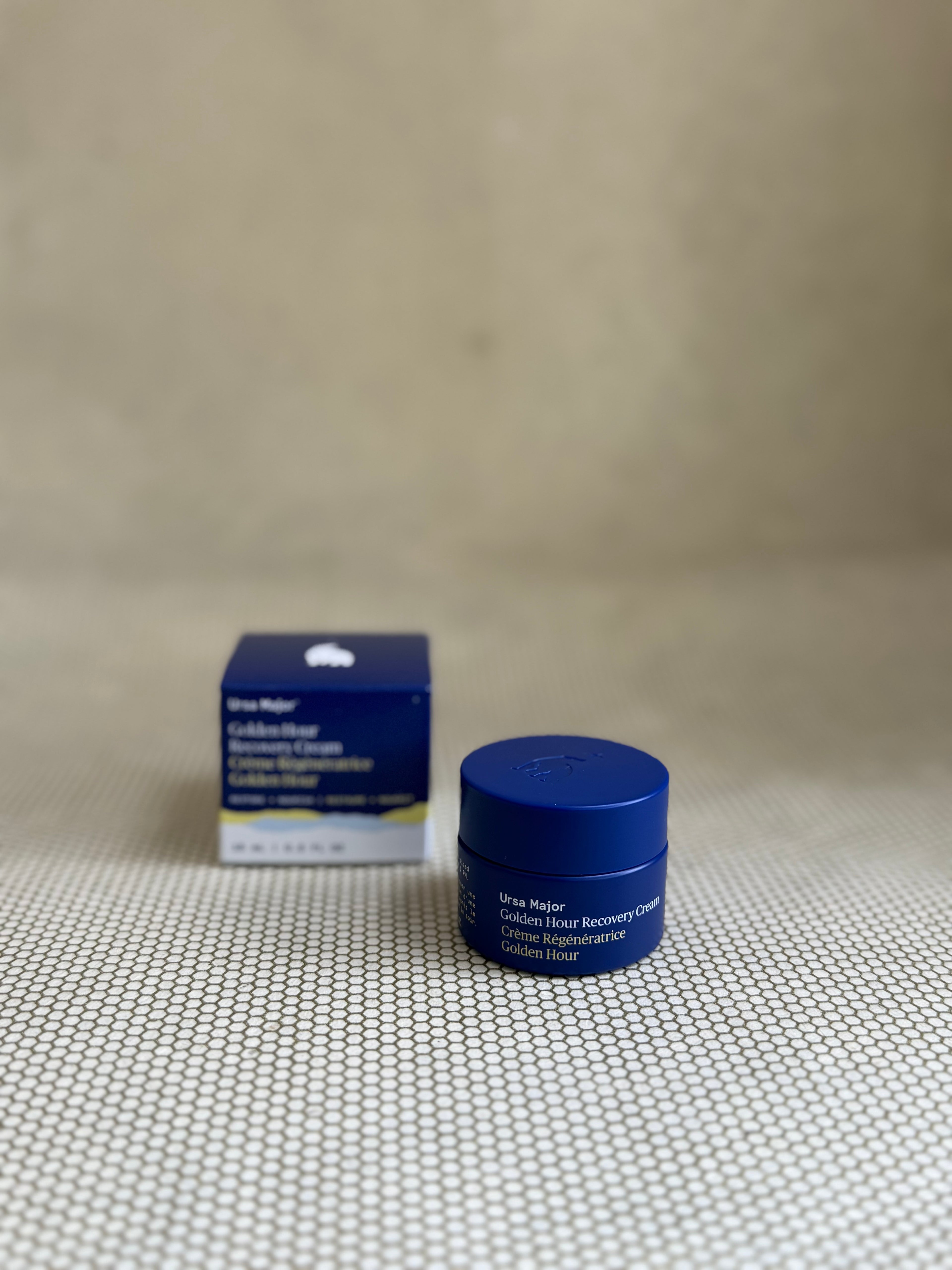 Blue traveler jar of Ursula Major Golden Hour Recovery Cream and box on a textured beige background