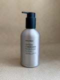 metallic bottle of Ursa Major "go easy" conditioner with pump on neutral background.