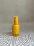 Yellow pump bottle of Ursa Major Mountain Glow Serum on neutral background. 