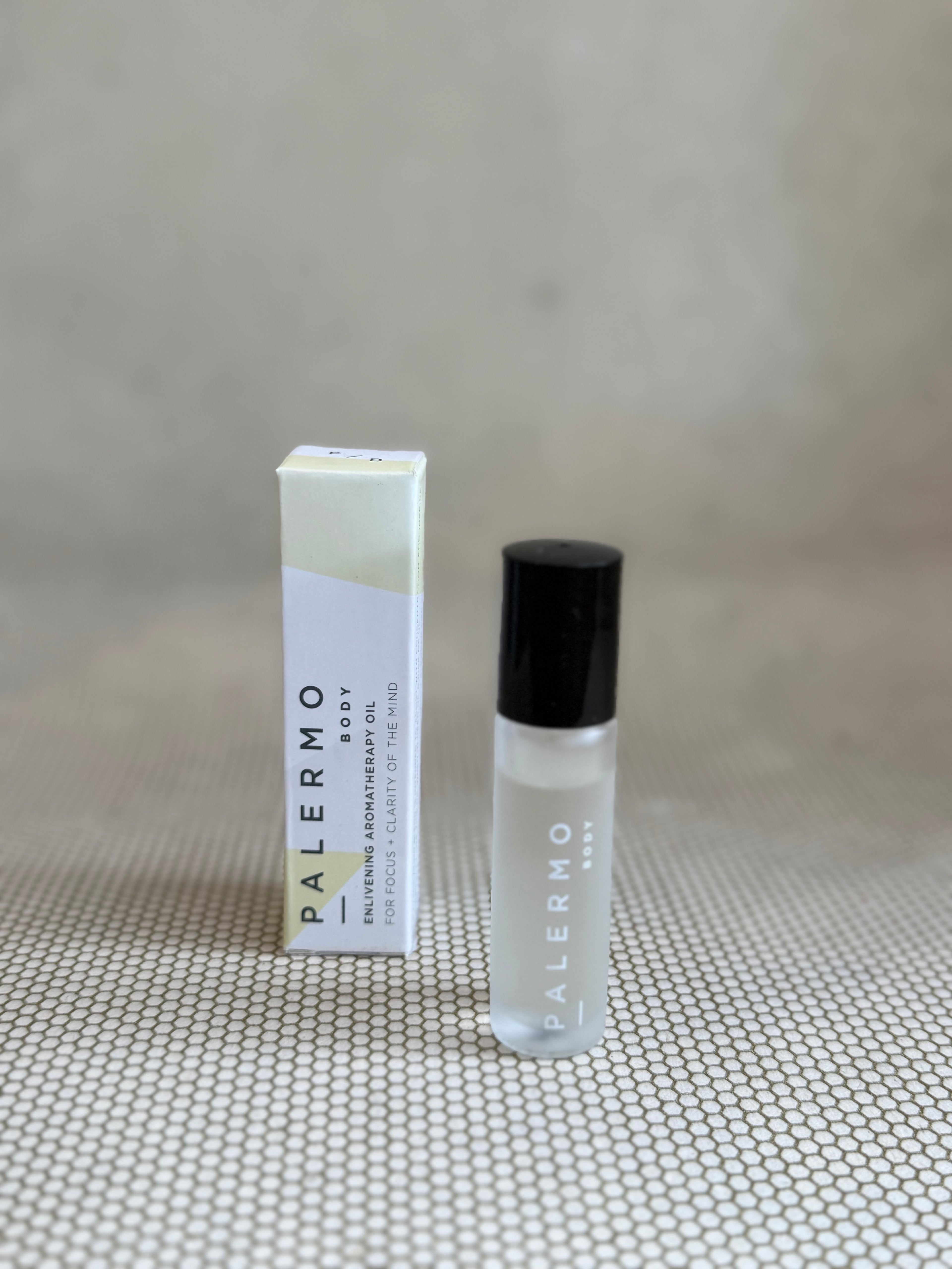 Roll-on bottle of Palermo body enlivening aromatherapy oil with small white and yellow box. 