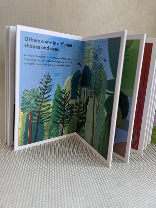 Open book with illustrations of trees and text on a textured surface