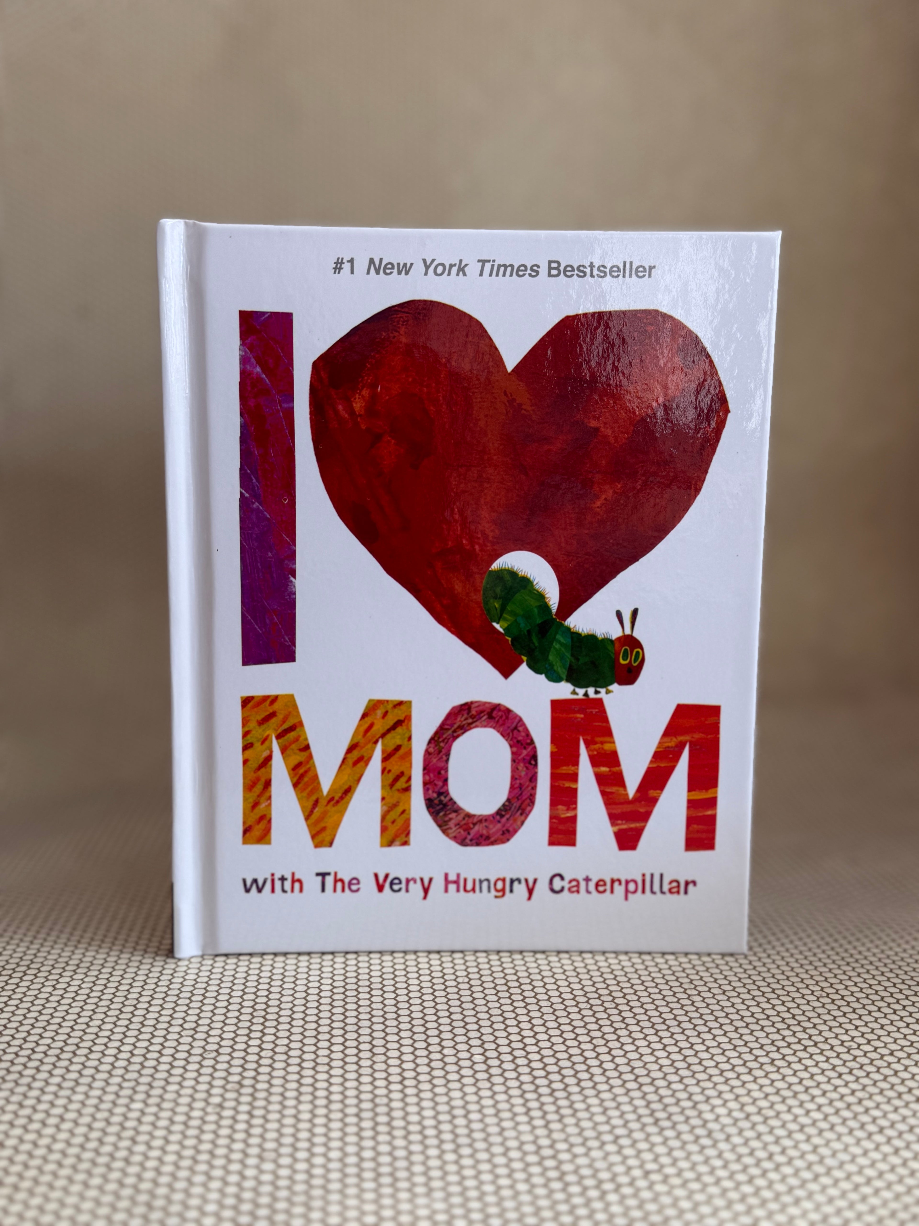 Book titled 'I ❤️ Mom with The Very Hungry Caterpillar' on a textured surface.