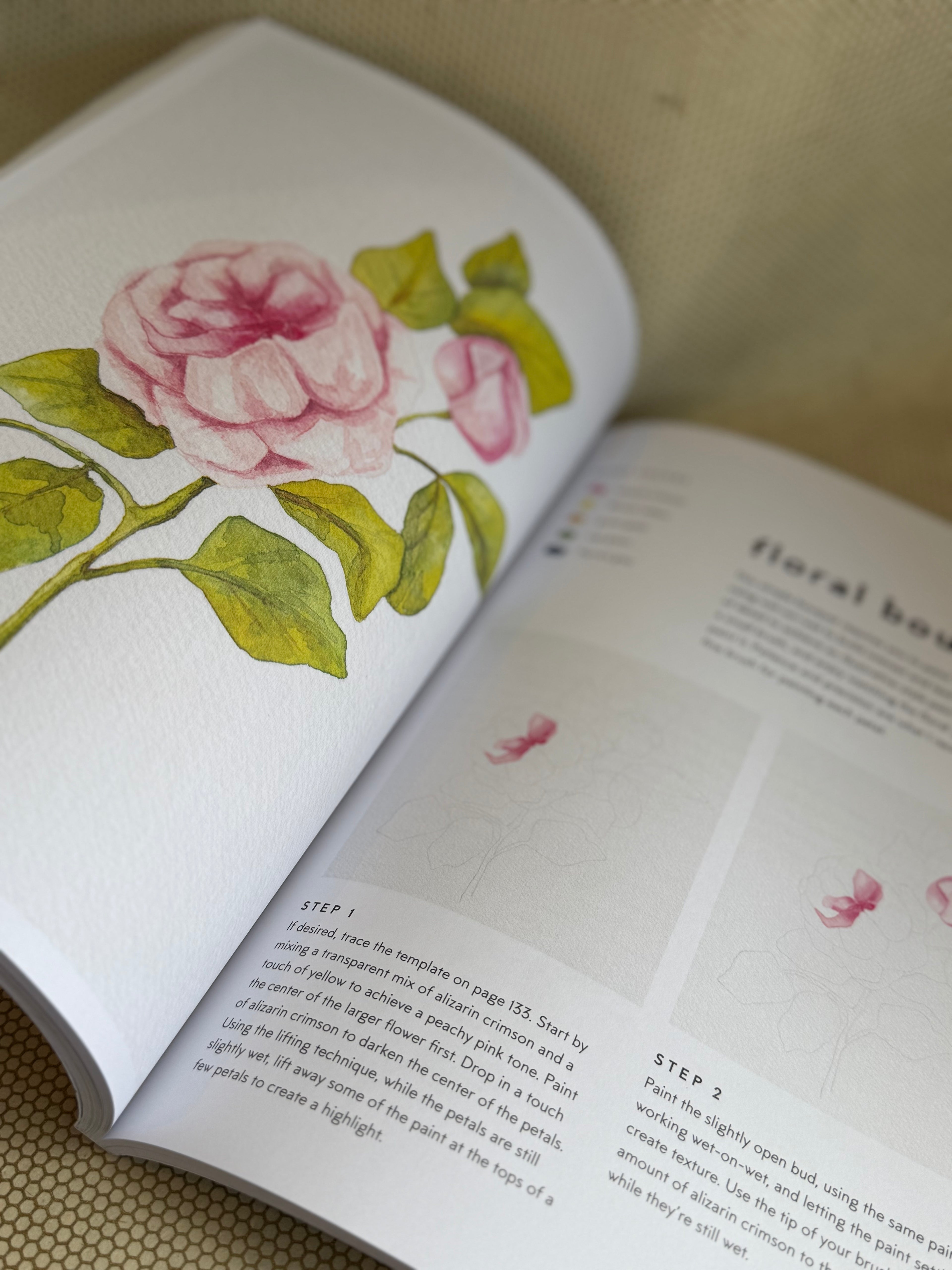 Open book with floral illustrations and text on a textured surface