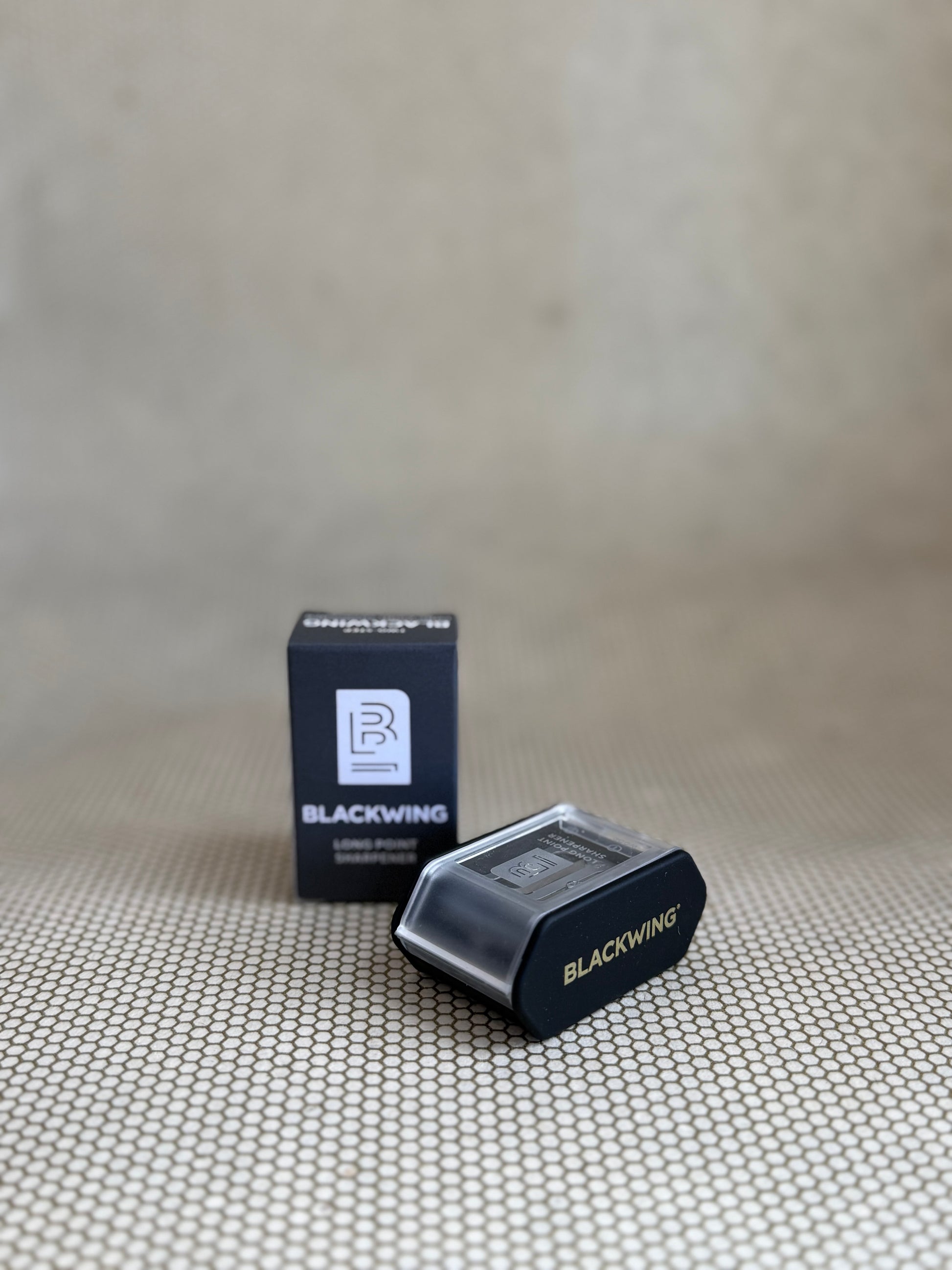 Blackwing pencil sharpener and packaging on a textured surface