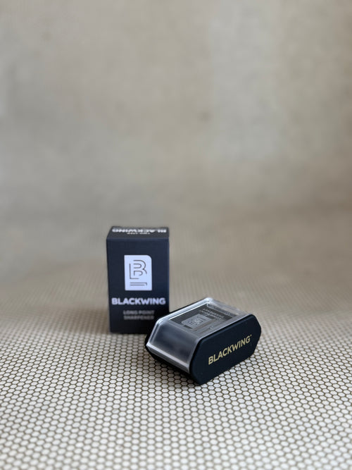 Blackwing pencil sharpener and packaging on a textured surface