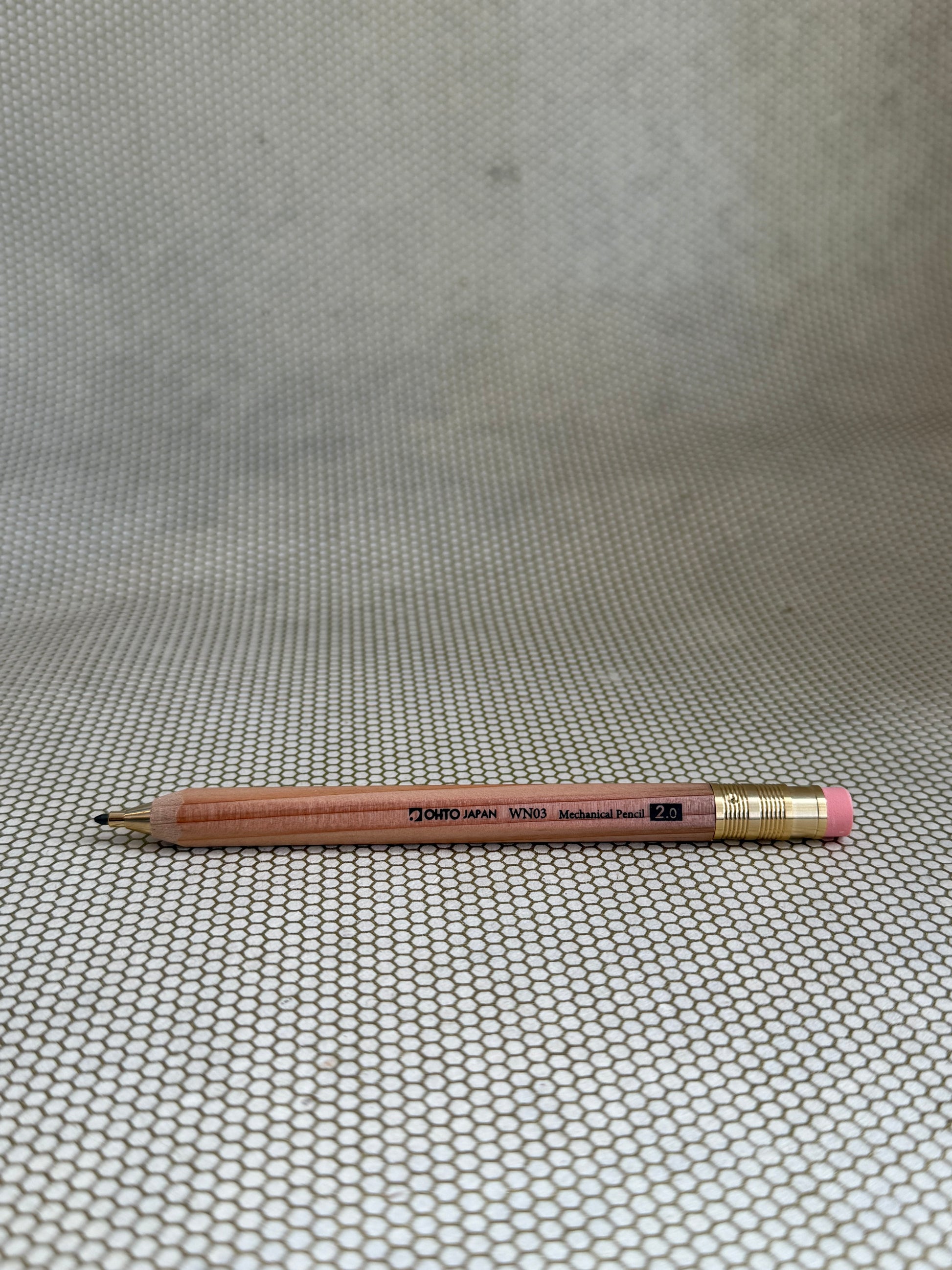 large wooden mechanical pencil with eraser on neutral background. 