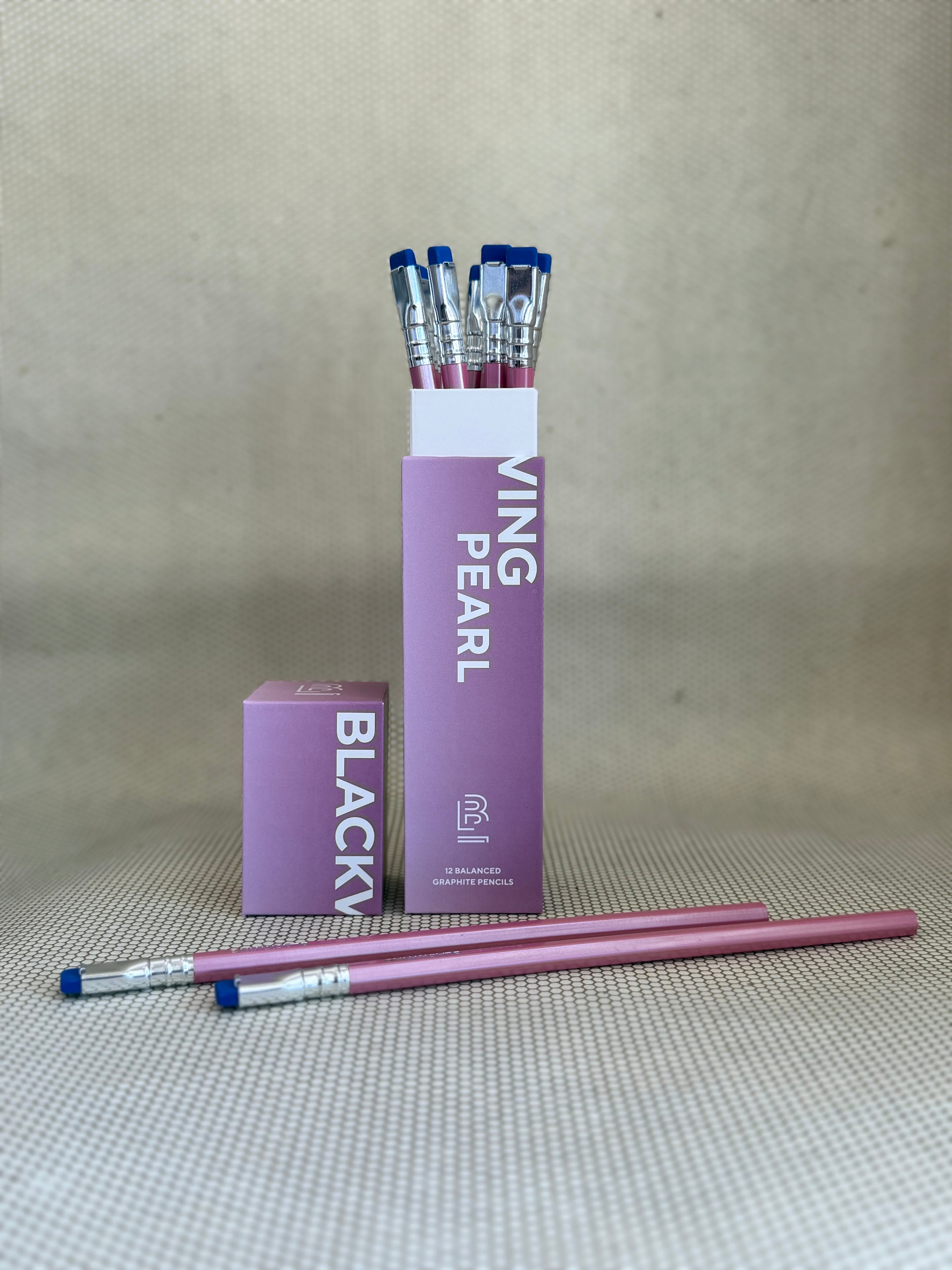 pink box of Blackwing pearl pencils with blue erasers and pink shells on neutral background. 