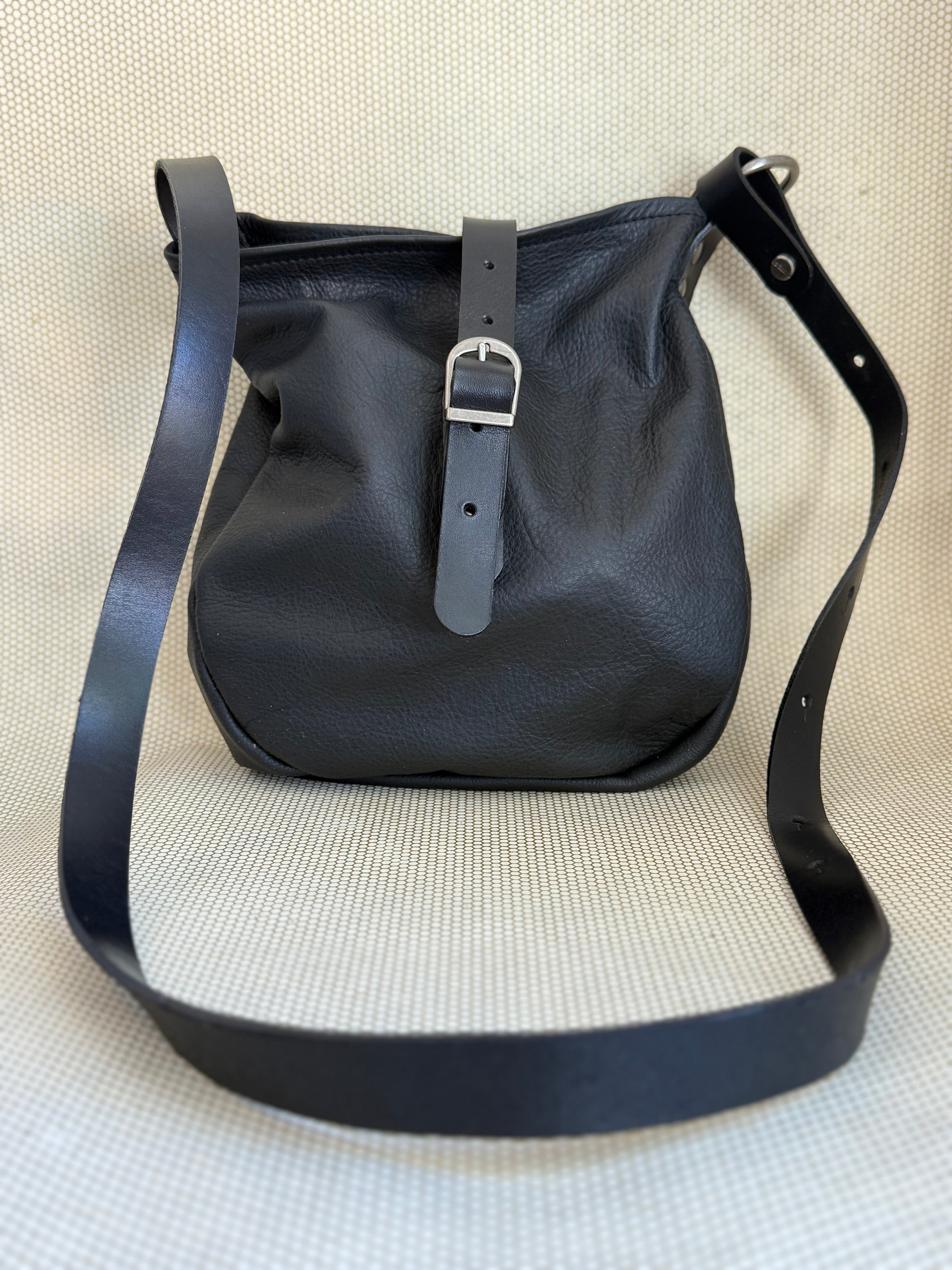 Black Dean leather handbag with a strap on a light background