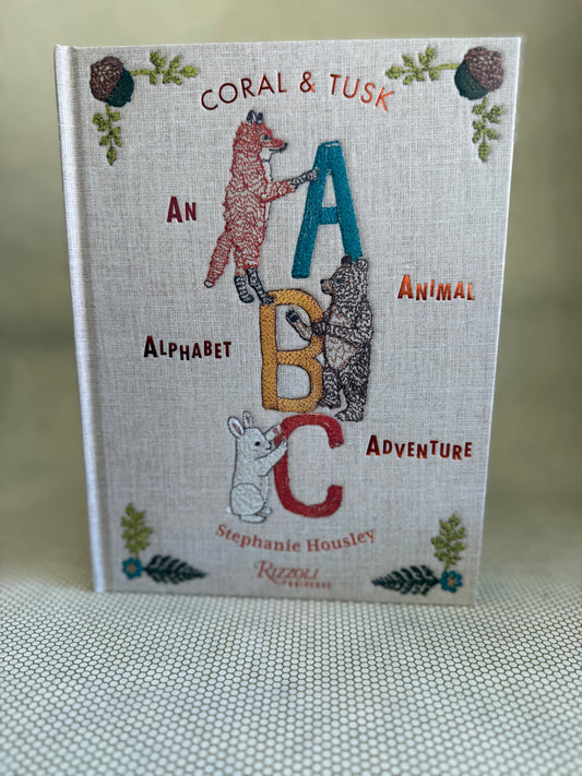 Book titled 'An Alphabet Animal Adventure' by Stephanie Housley with animal illustrations on a textured surface.