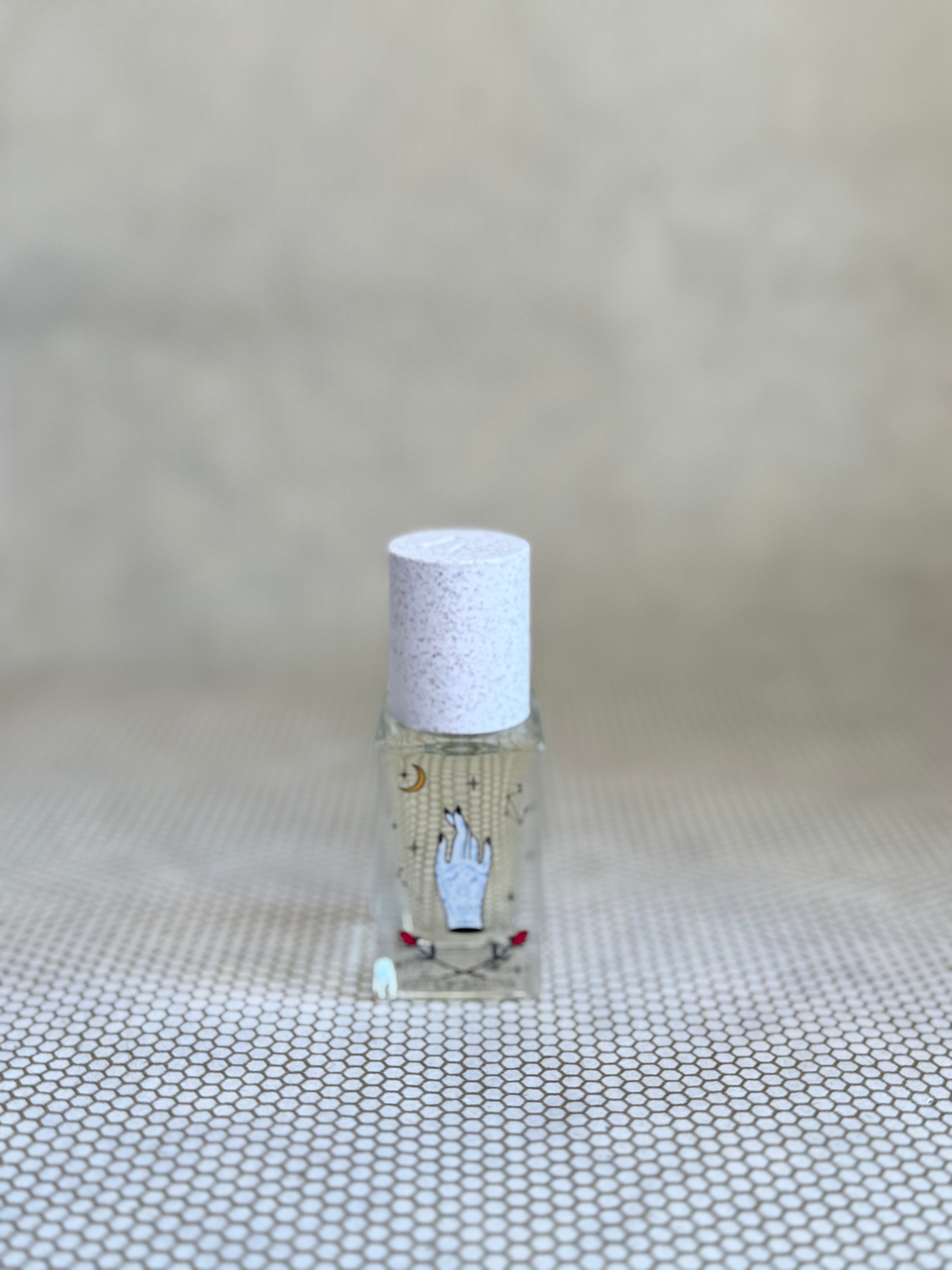 small glass bottle of maison matine perfume with hand drawing design on bottle. 