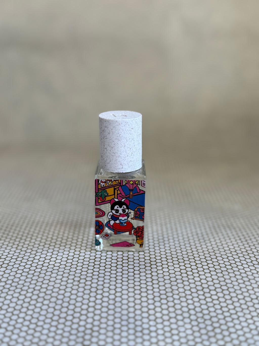 small glass bottle of maison matine perfume with cat design.