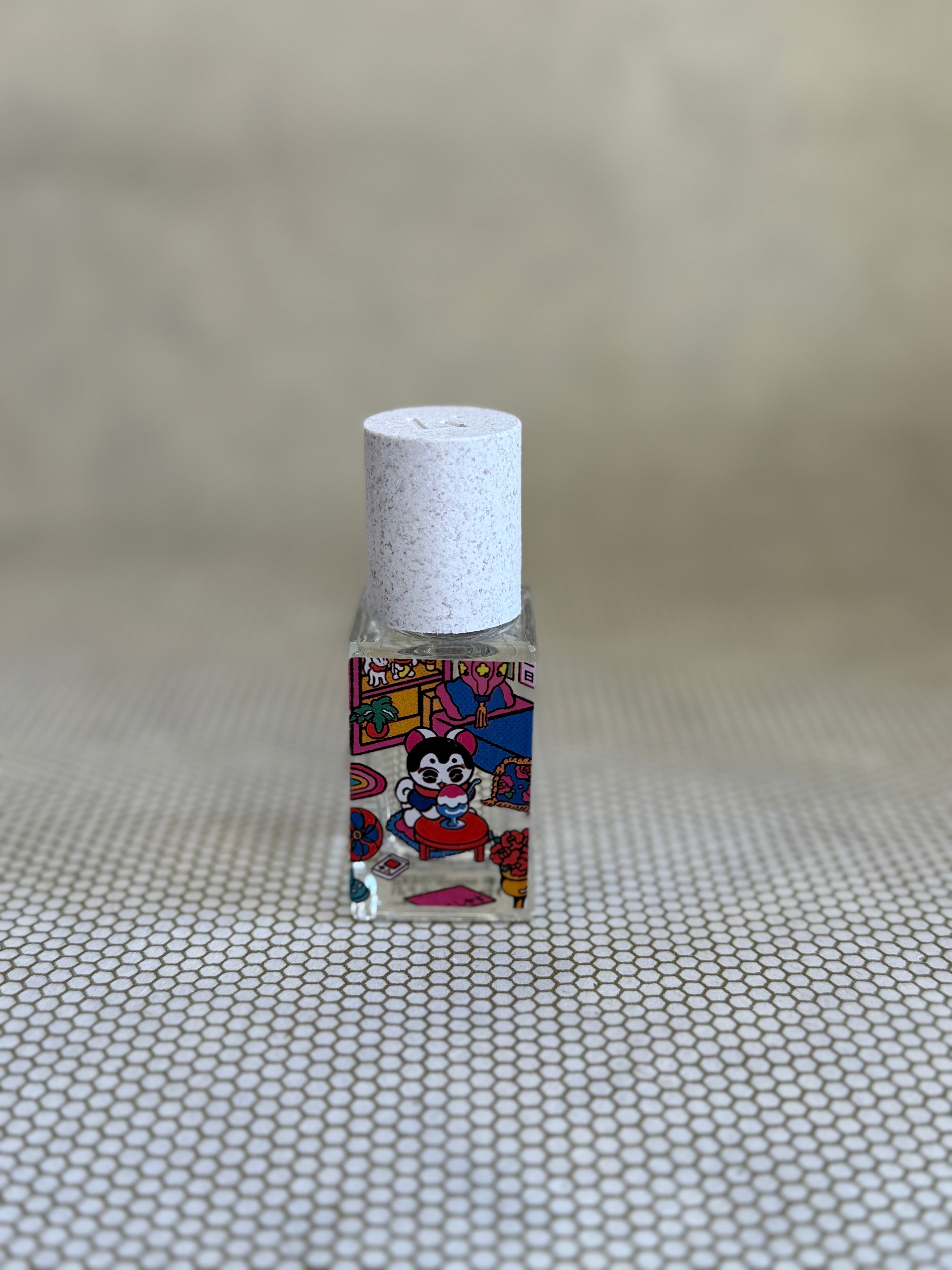 small glass bottle of maison matine perfume with cat design.