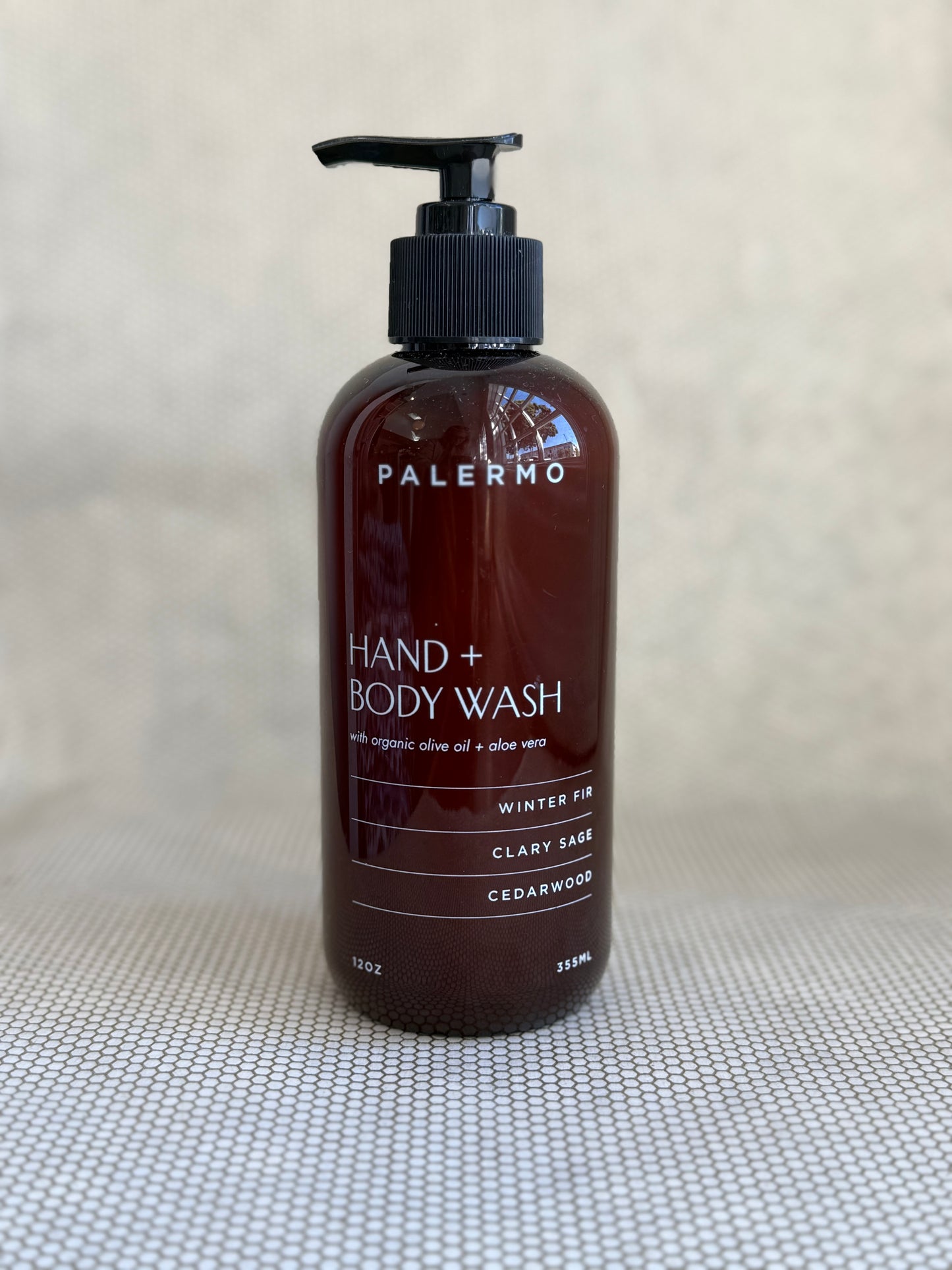 brown pump bottle of Palermo hand and body wash on neutral background. 