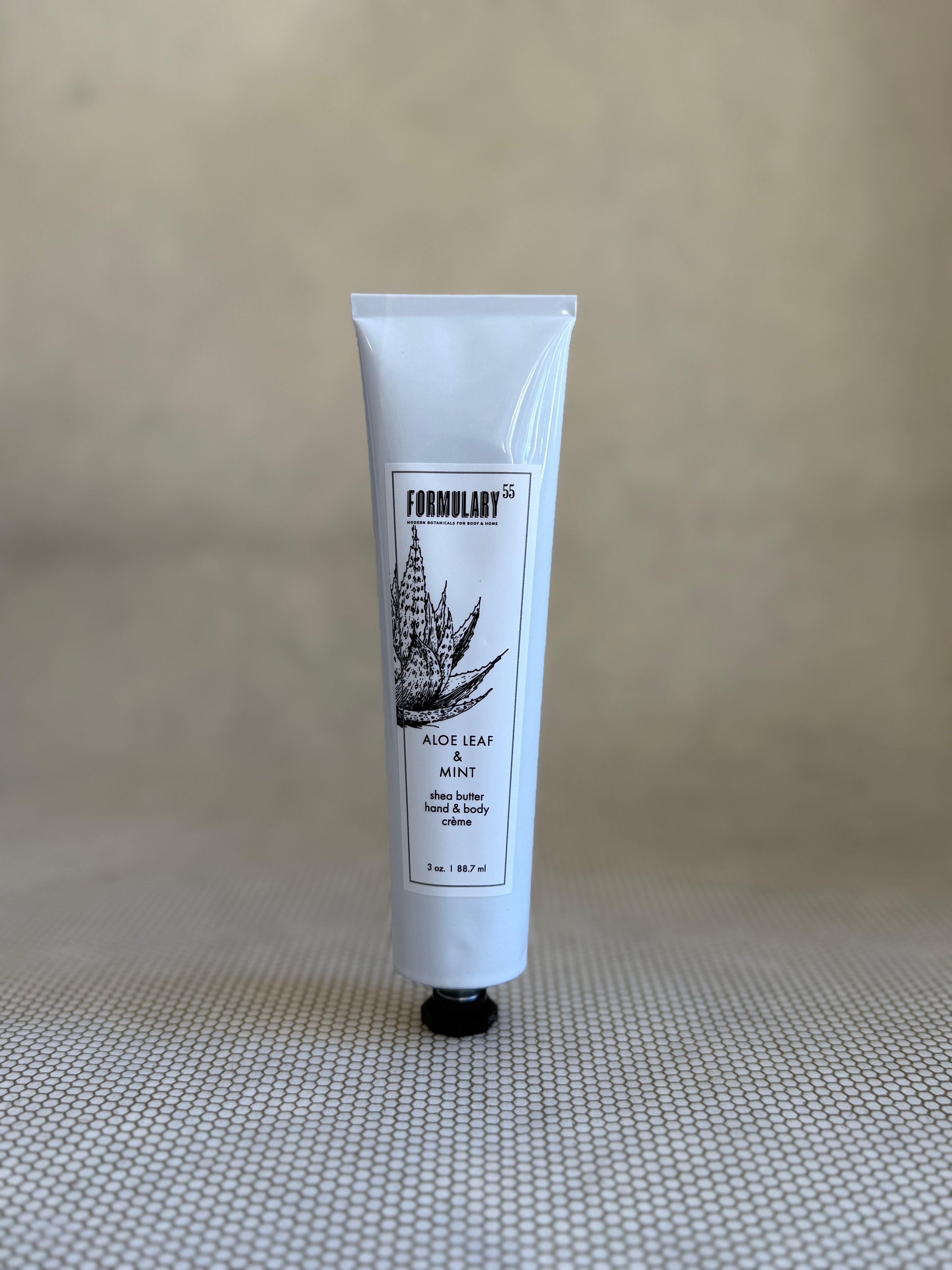 Tube of Formulary 55 aloe vera hand and body lotion on a neutral background