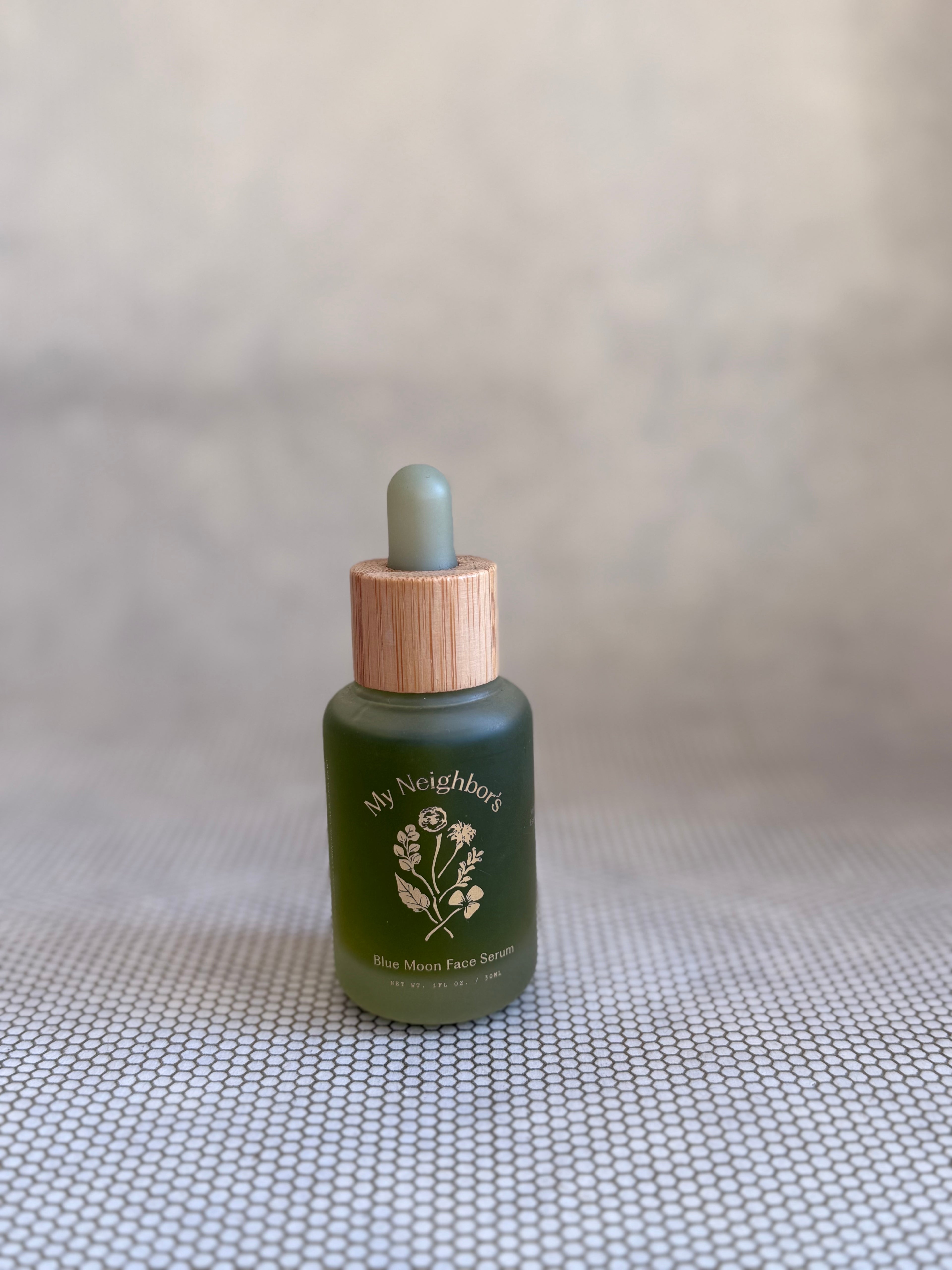 Green dropper bottle of My Neighbor's blue moon face serum. 