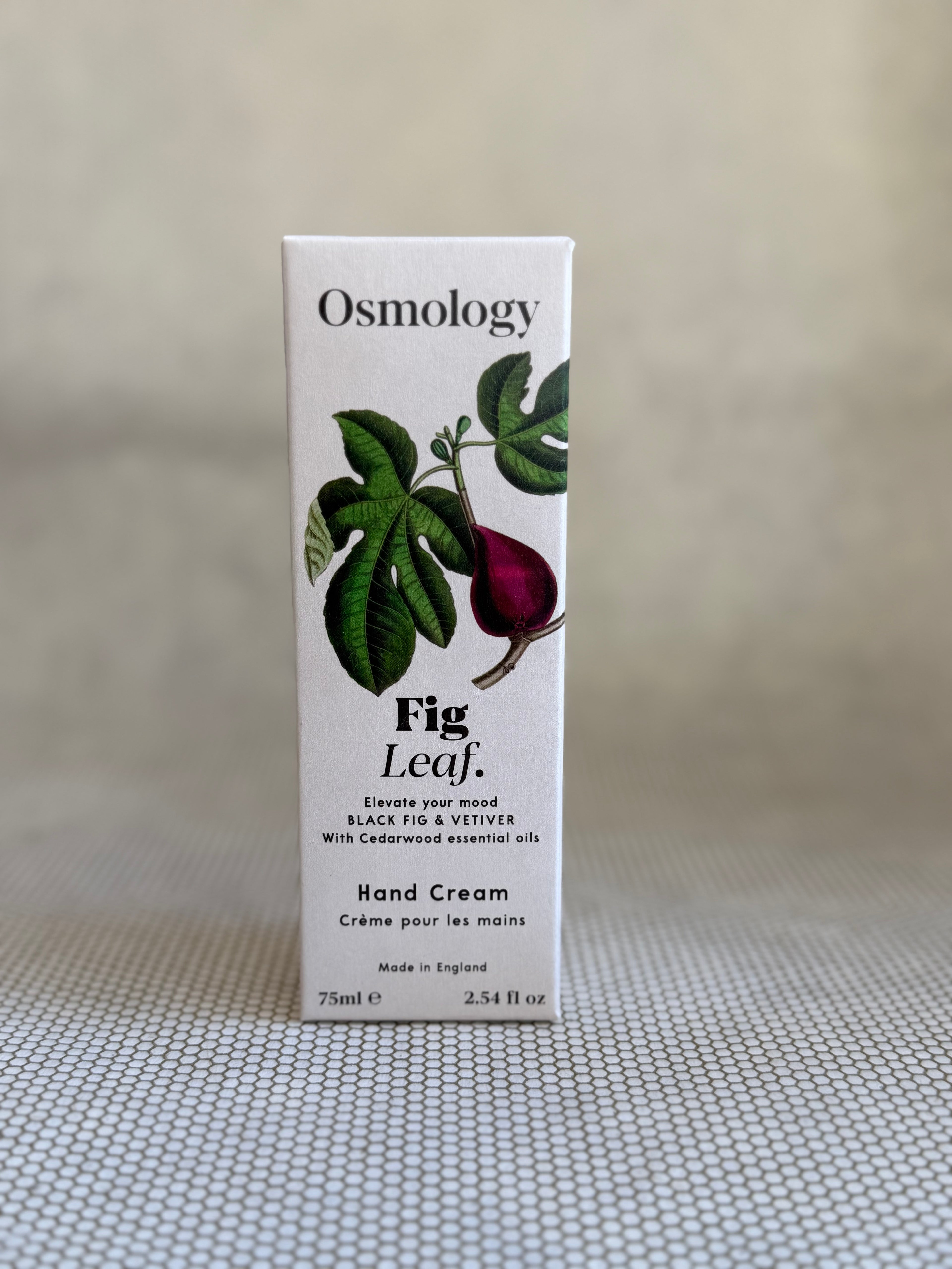 Osmology Fig Leaf hand cream packaging on a neutral background