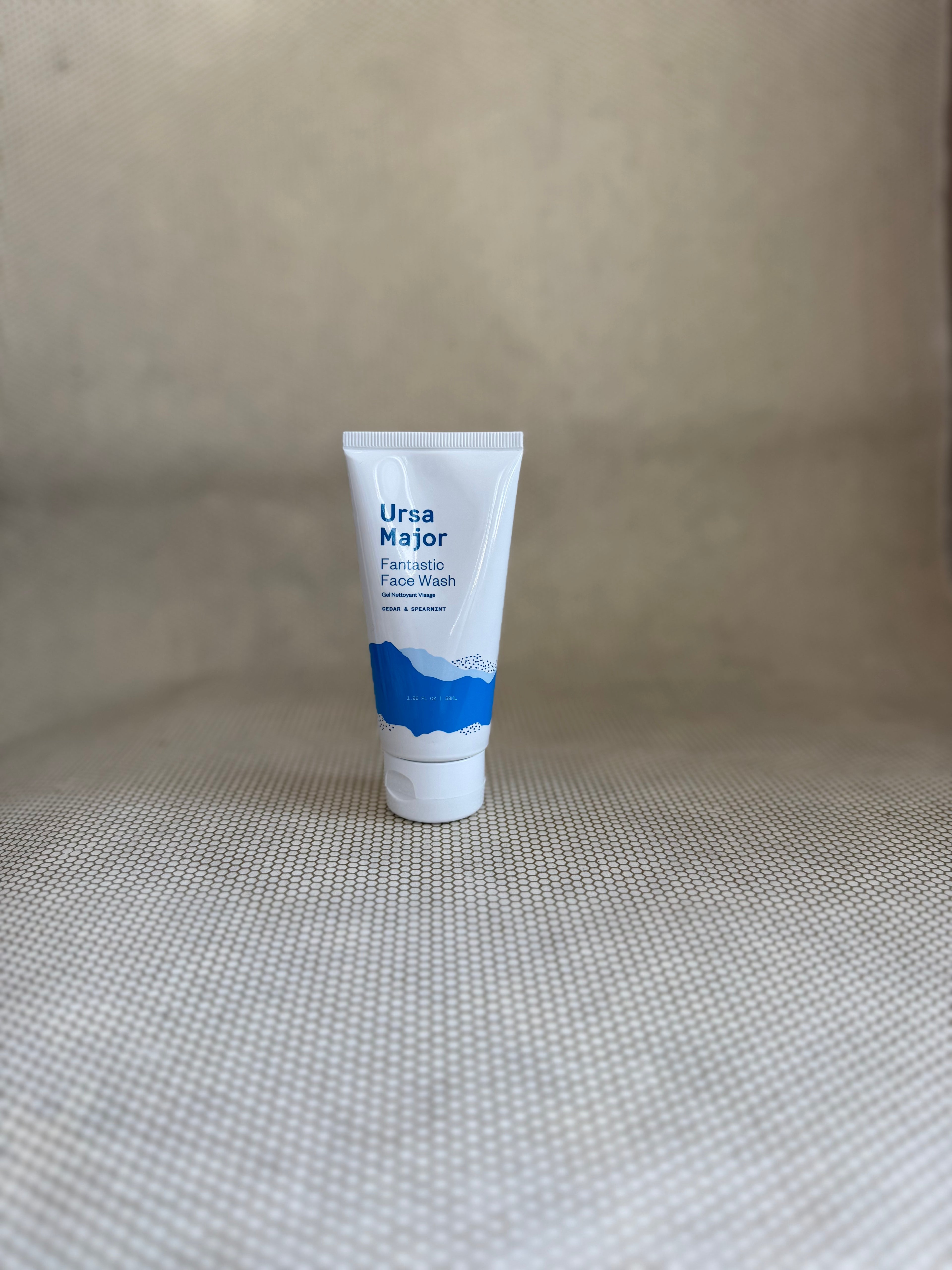 Ursa Major fantastic face wash traveler tube on a textured beige surface