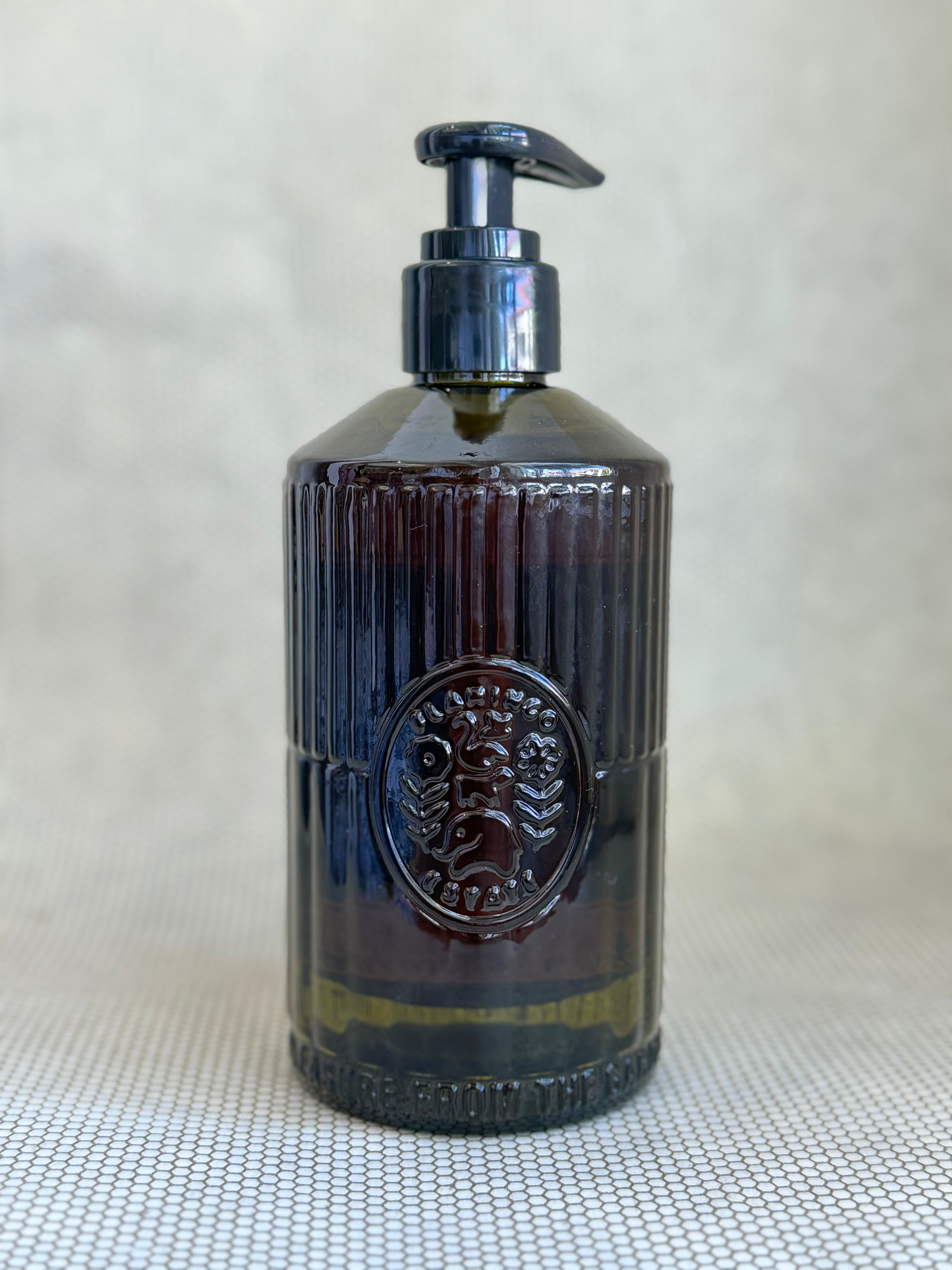 dark green glass pump bottle of flamingo estate hand soap jasmine damask rose