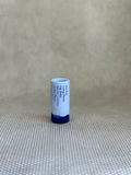 tube of Ursa Major Going Places Lip Balm in blue packaging. 