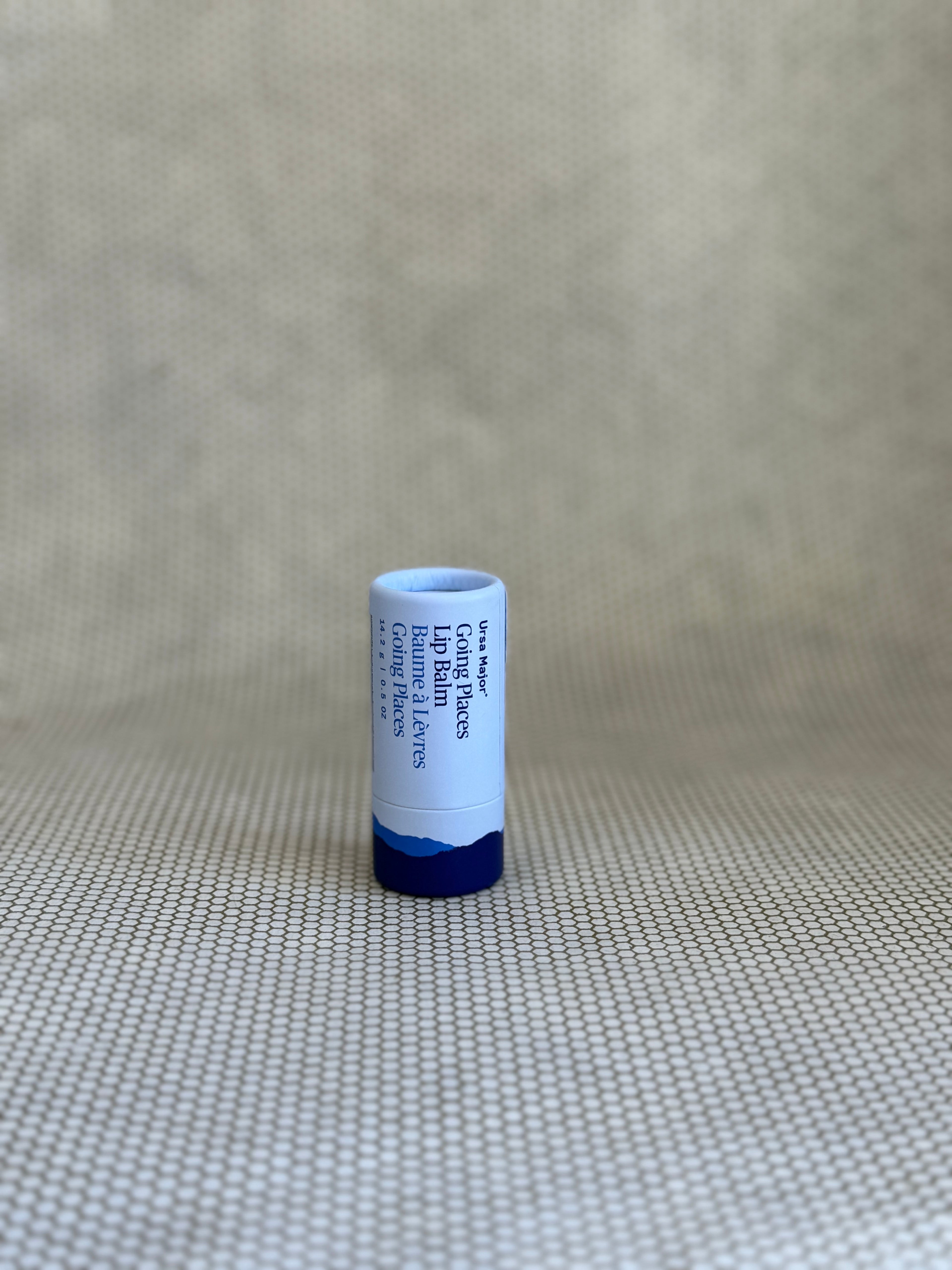 tube of Ursa Major Going Places Lip Balm in blue packaging. 