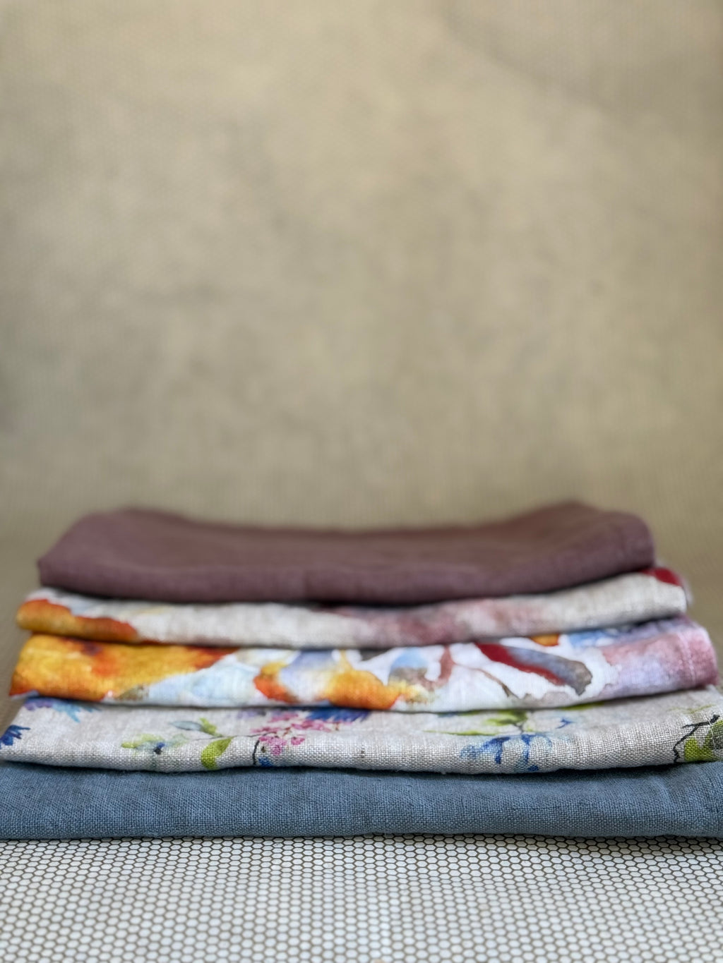stacked kitchen towels in varying colors. Linen Tales 100% linen 18''x26''