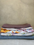 stacked kitchen towels in varying colors. Linen Tales 100% linen 18''x26''