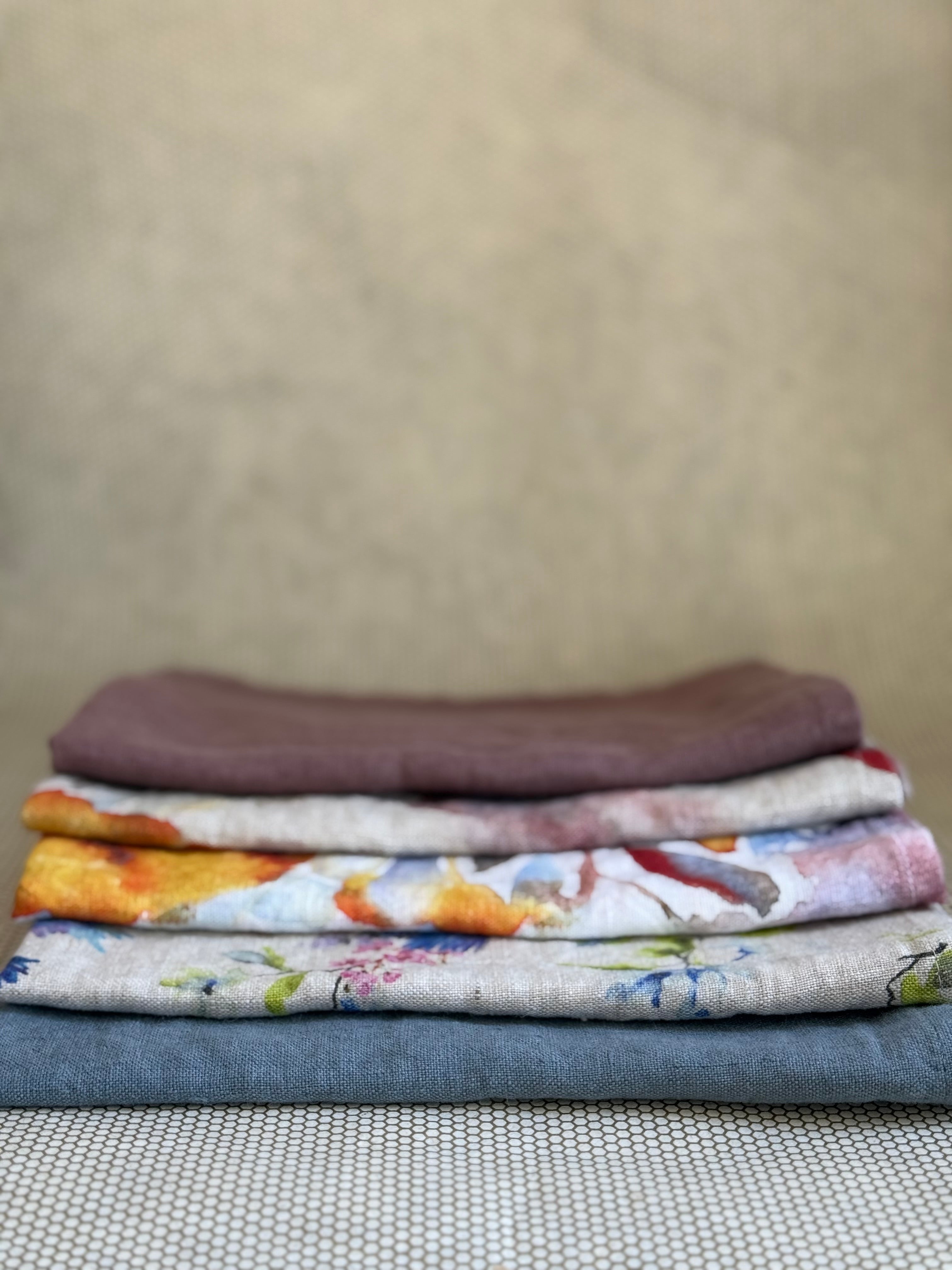 stacked kitchen towels in varying colors. Linen Tales 100% linen 18''x26''