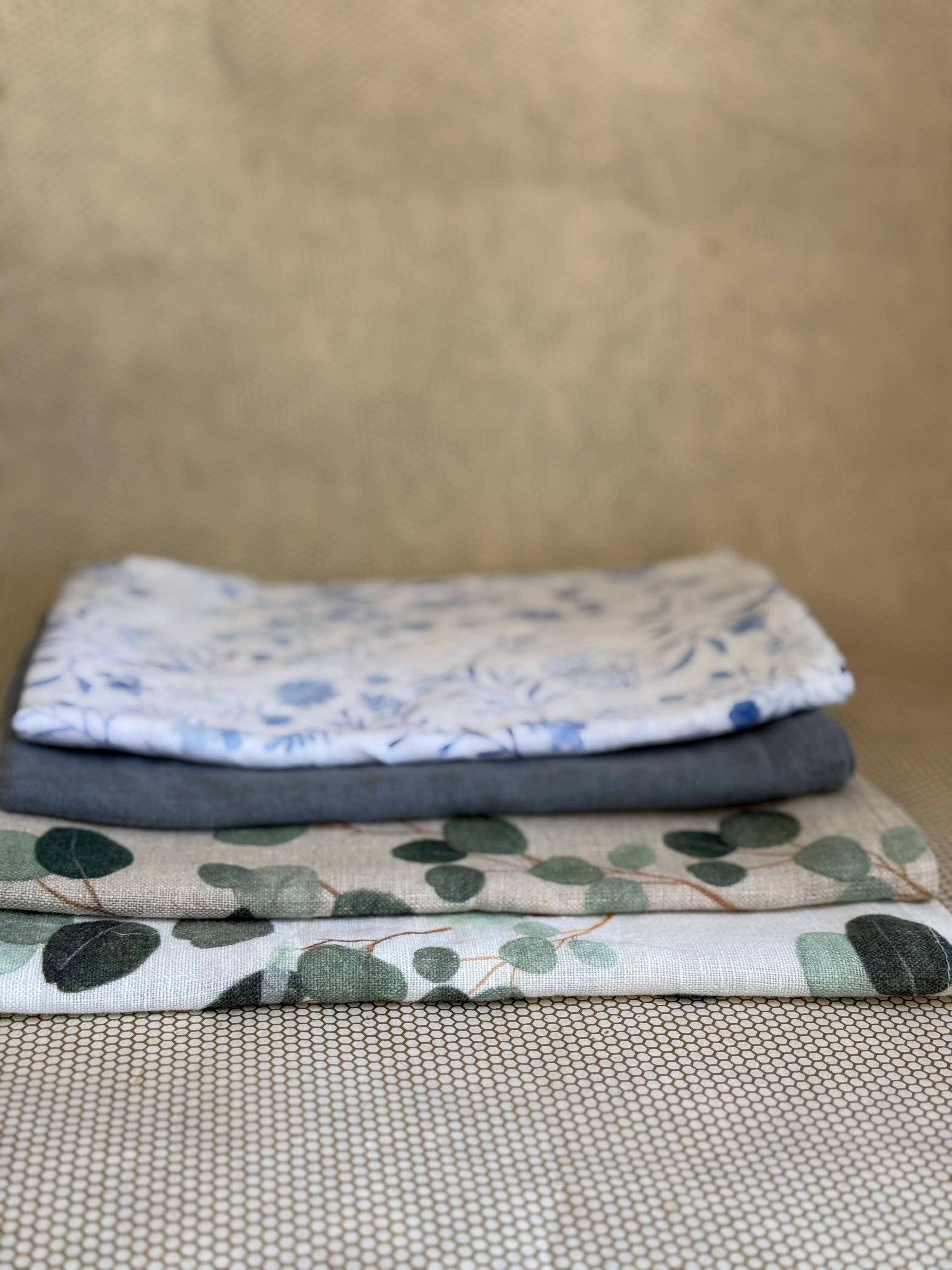 stacked kitchen towels in varying colors. Linen Tales 100% linen 18''x26''