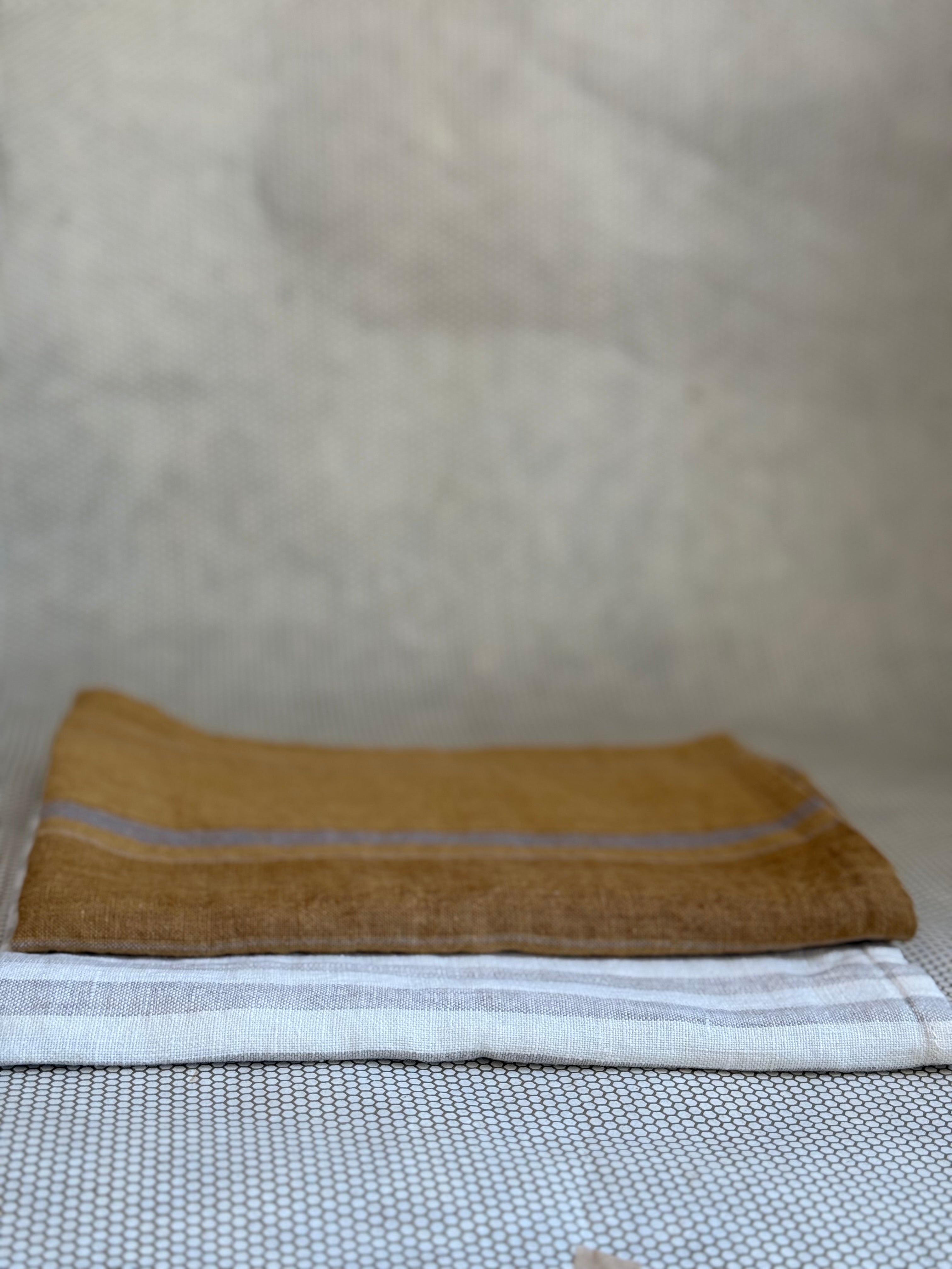 stacked kitchen towels in varying colors. Linen Tales 100% linen 18''x26''