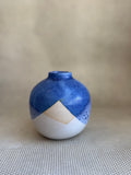 Blue and white ceramic vase on a textured surface with a neutral background