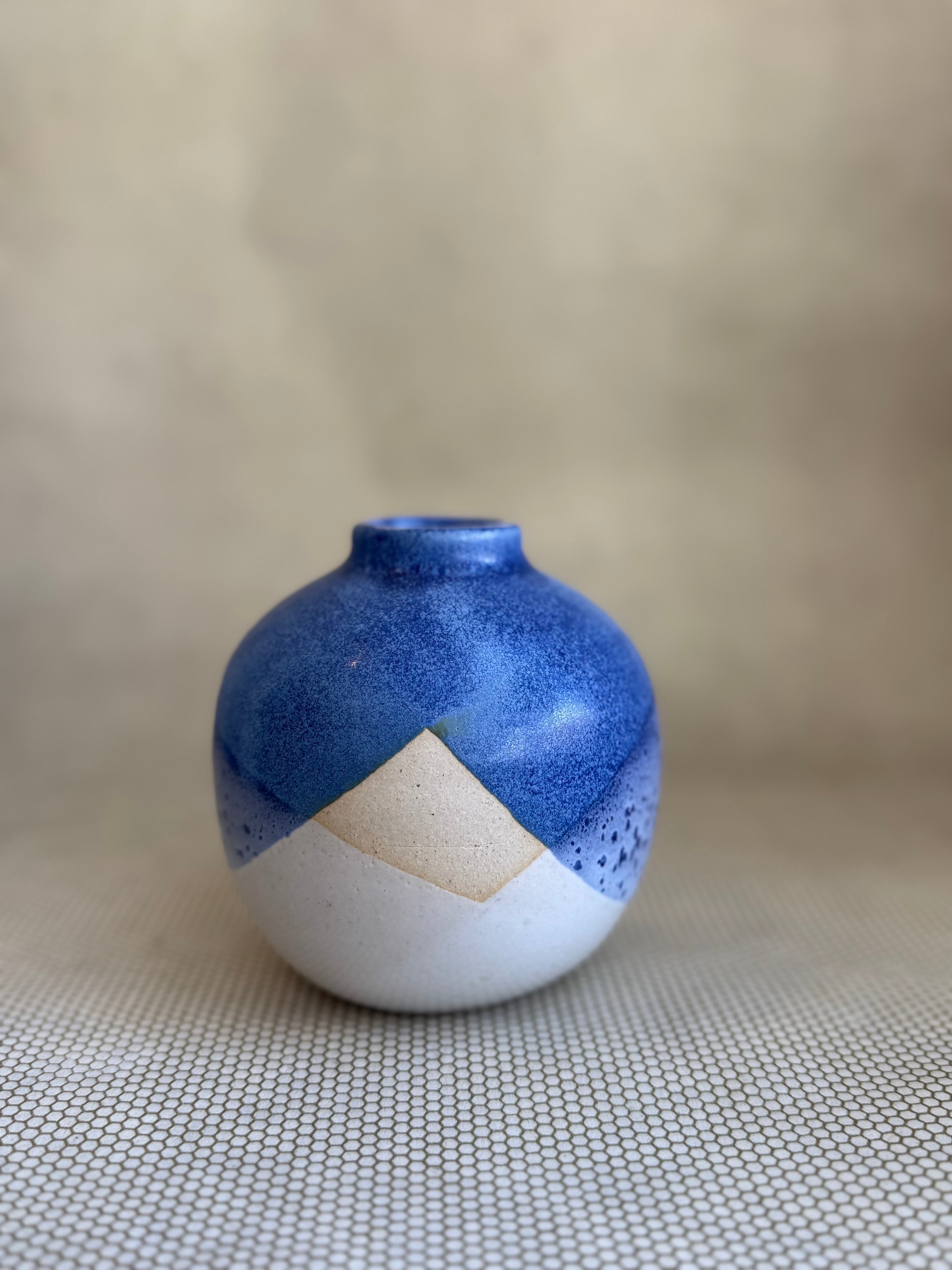 Blue and white ceramic vase on a textured surface with a neutral background