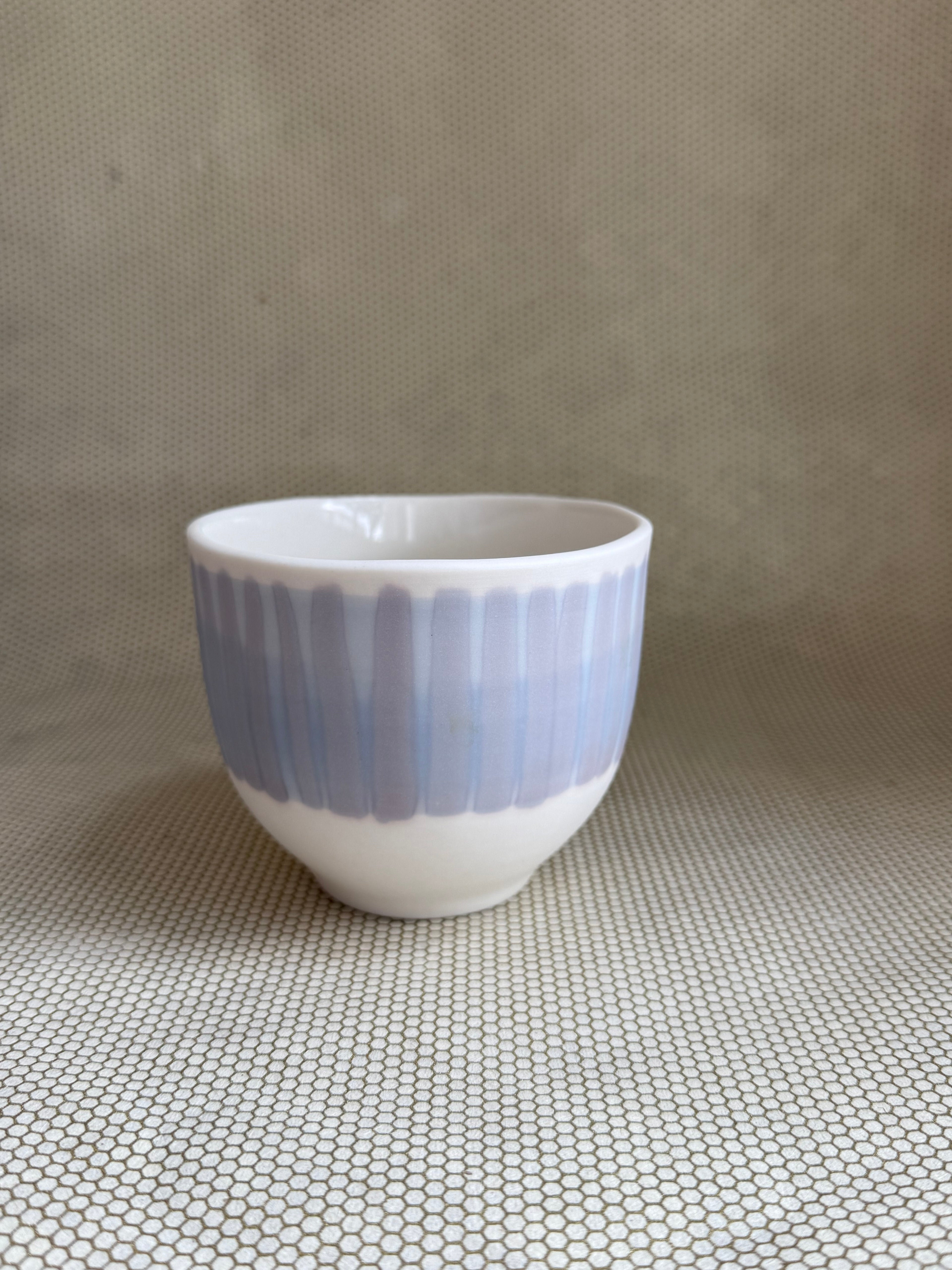 lavender and blue porcelain handcrafted latte cup on neutral background. 