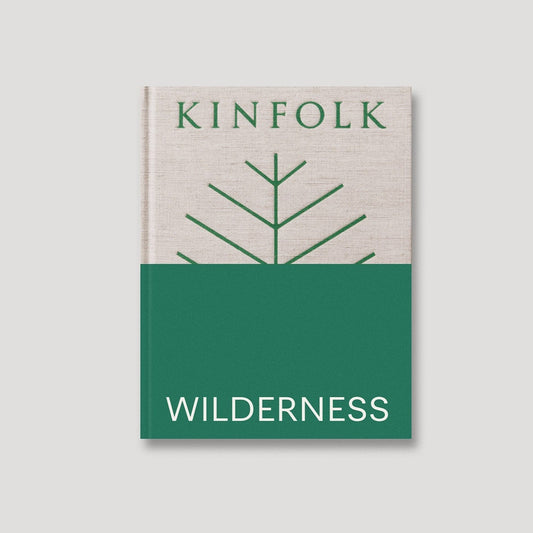 The cover of the book 'Kinfolk Wilderness', featuring a minimalist design with a green and white color scheme and a stylized tree graphic.